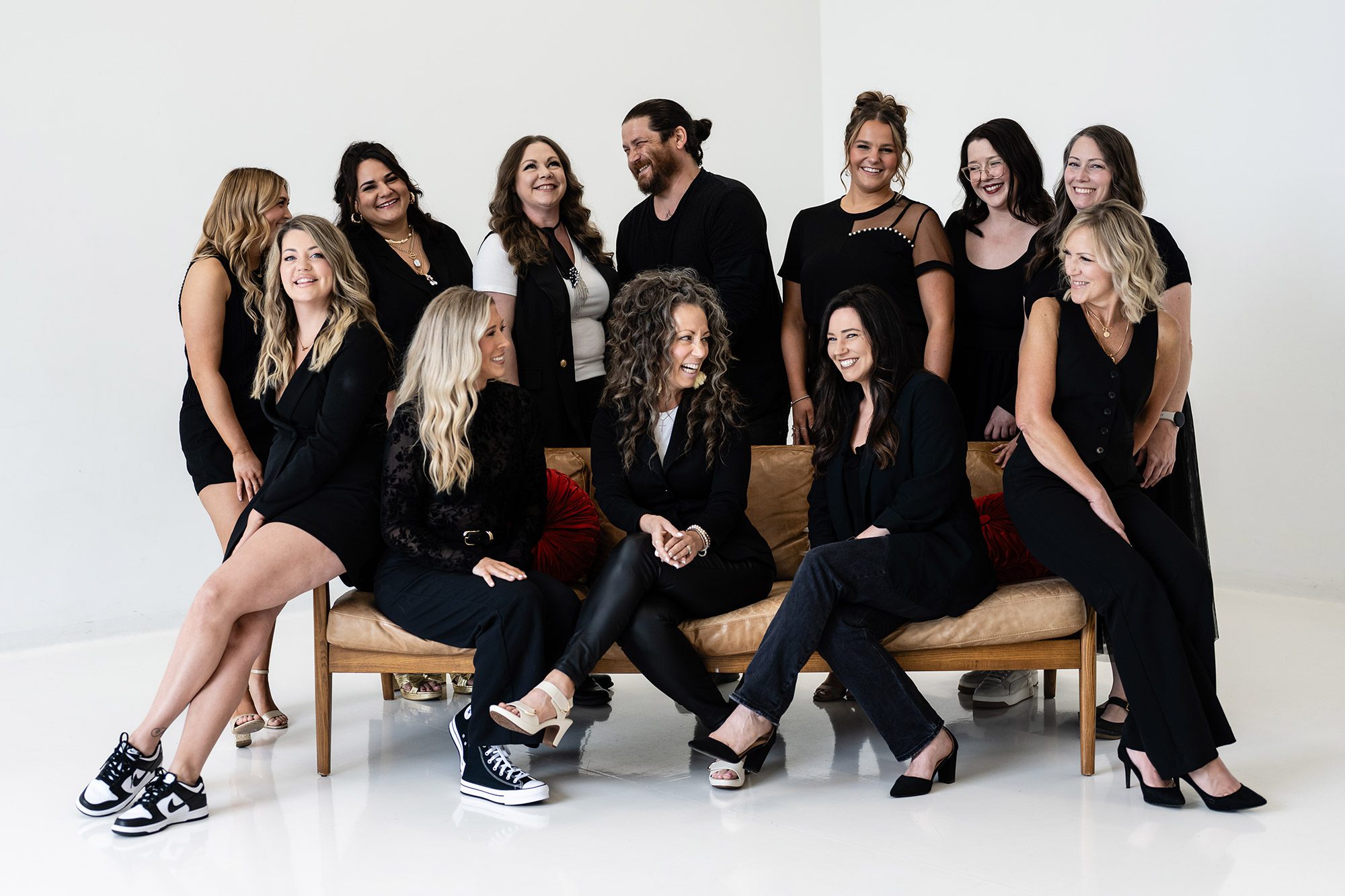 the tangles salon team dressed in black and sitting on a couch